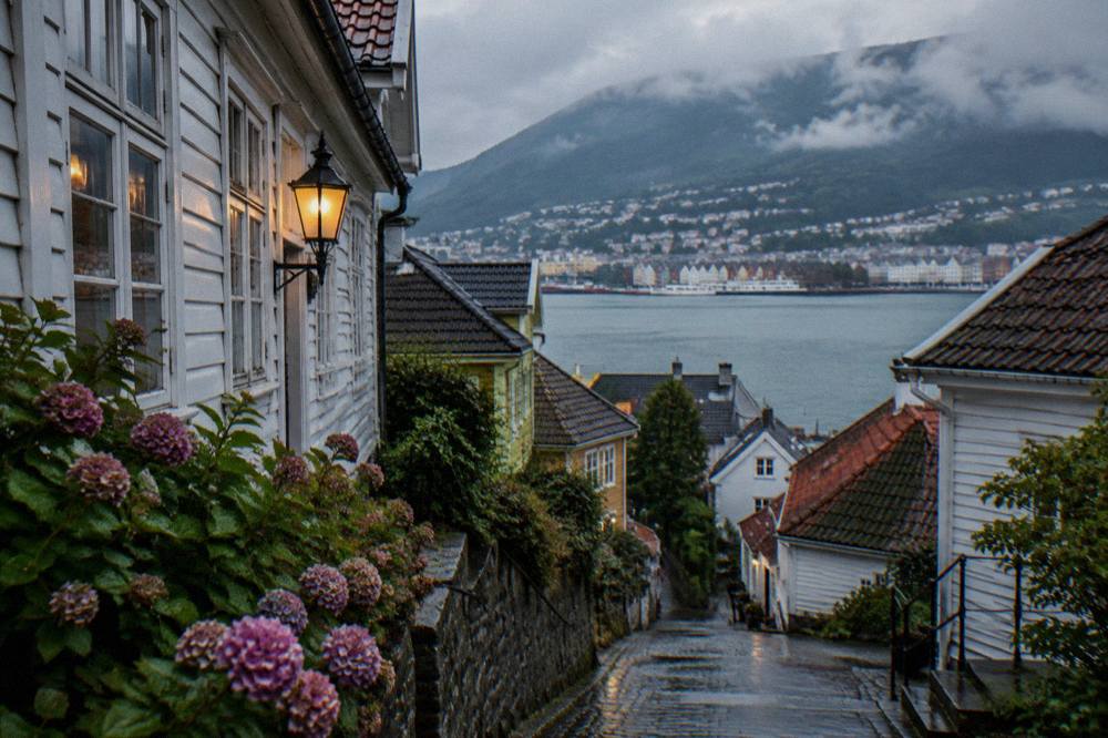 Wooden houses and narrow lanes on a hillside above the Bergen waterfront at dusk
