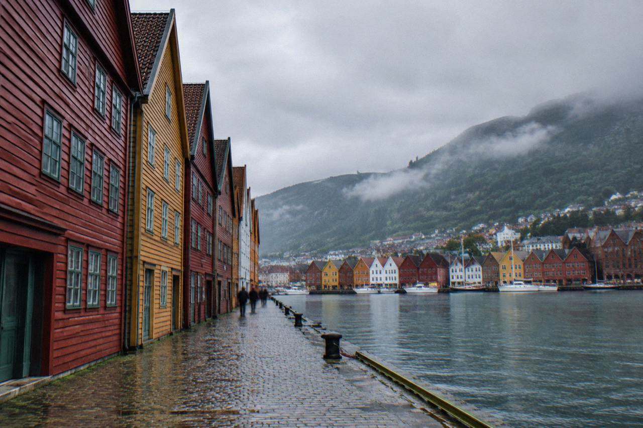 Colourful wooden warehouses of the Bryggen wharf in Bergen seen across the harbour on a soft morning