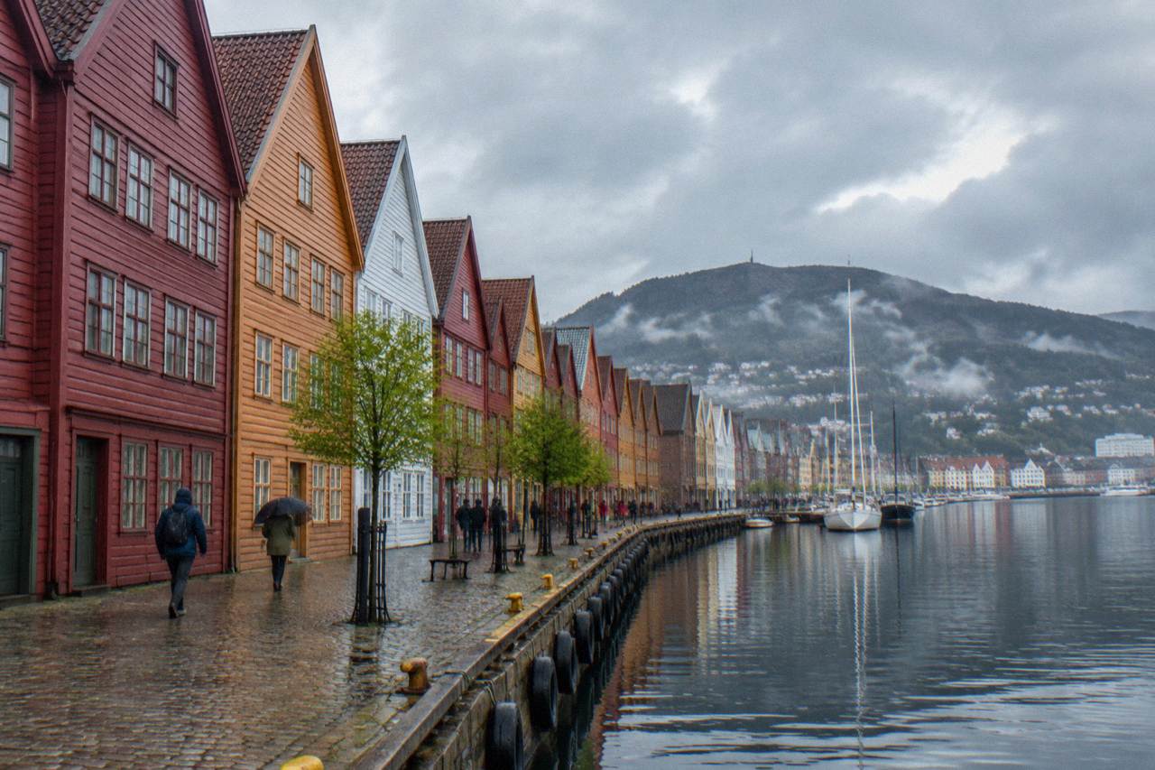 Bryggen wharf in Bergen with colourful wooden buildings reflected in the harbour on an overcast March day