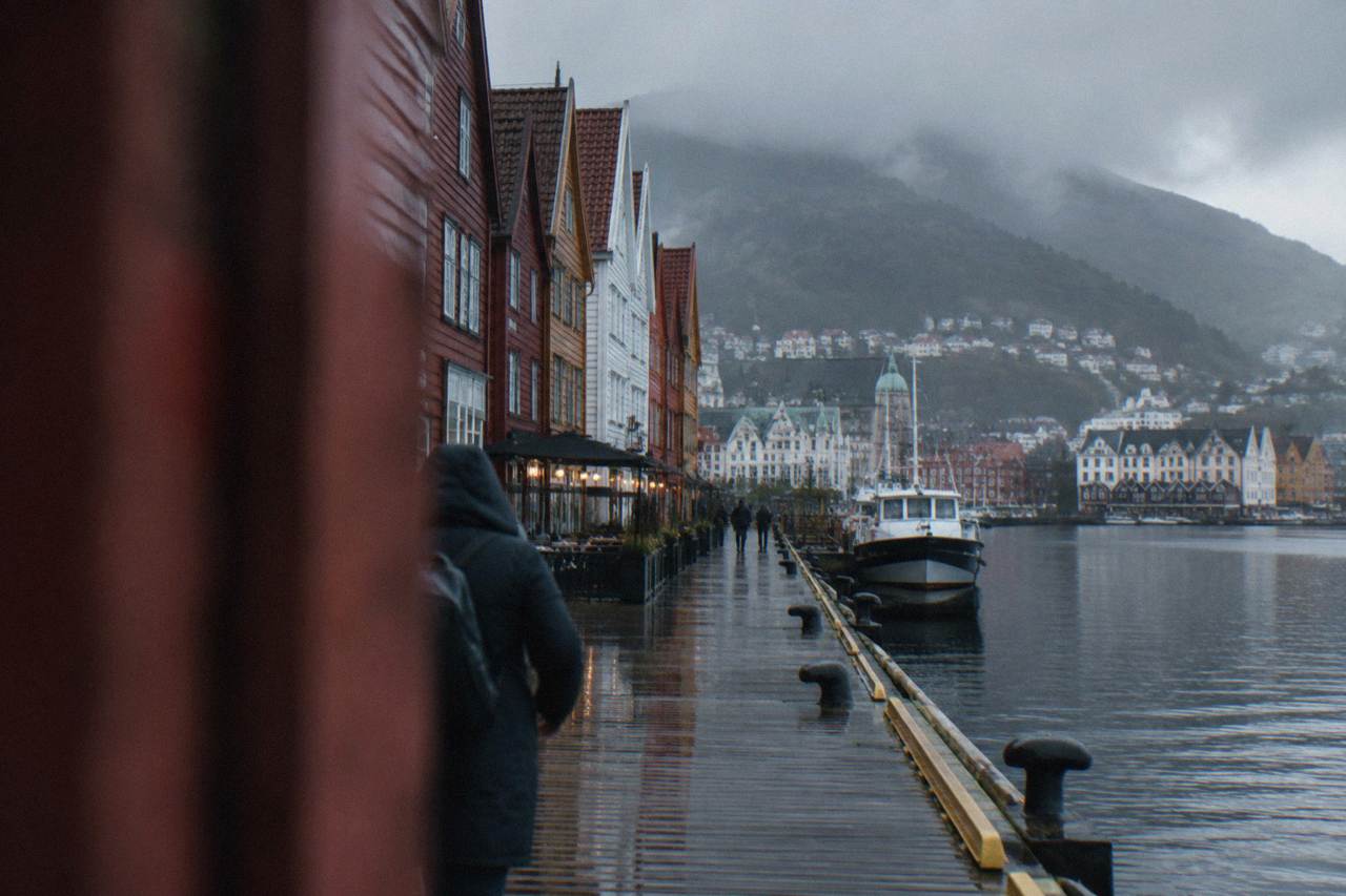 Rain-slicked wooden buildings along the waterfront in Bergen on a cool, overcast day