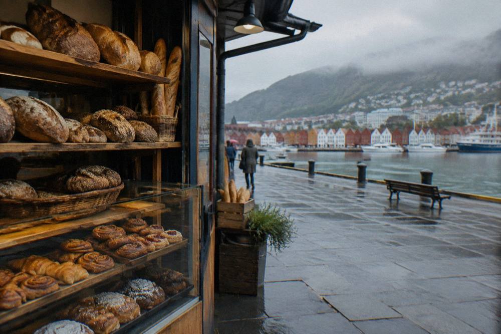 A small Bergen bakery counter with fresh bread and pastries on wooden shelves