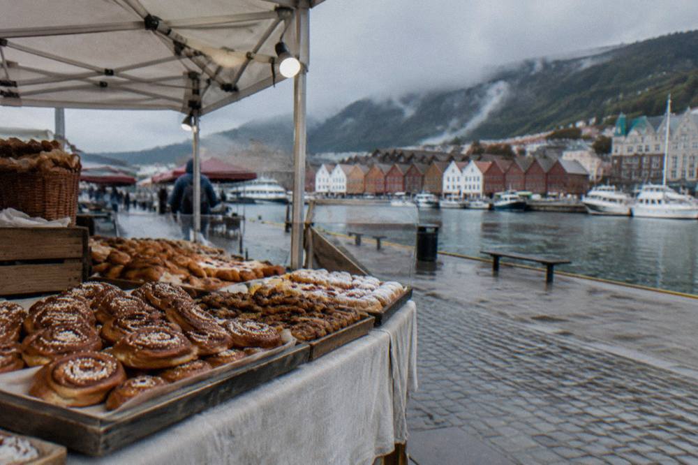 Baker's stall with cinnamon buns and pastries under a canopy in a Bergen market square