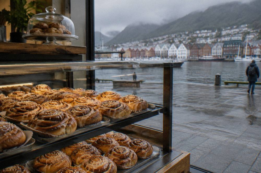 A bakery counter in central Bergen with trays of glazed cinnamon buns behind the glass