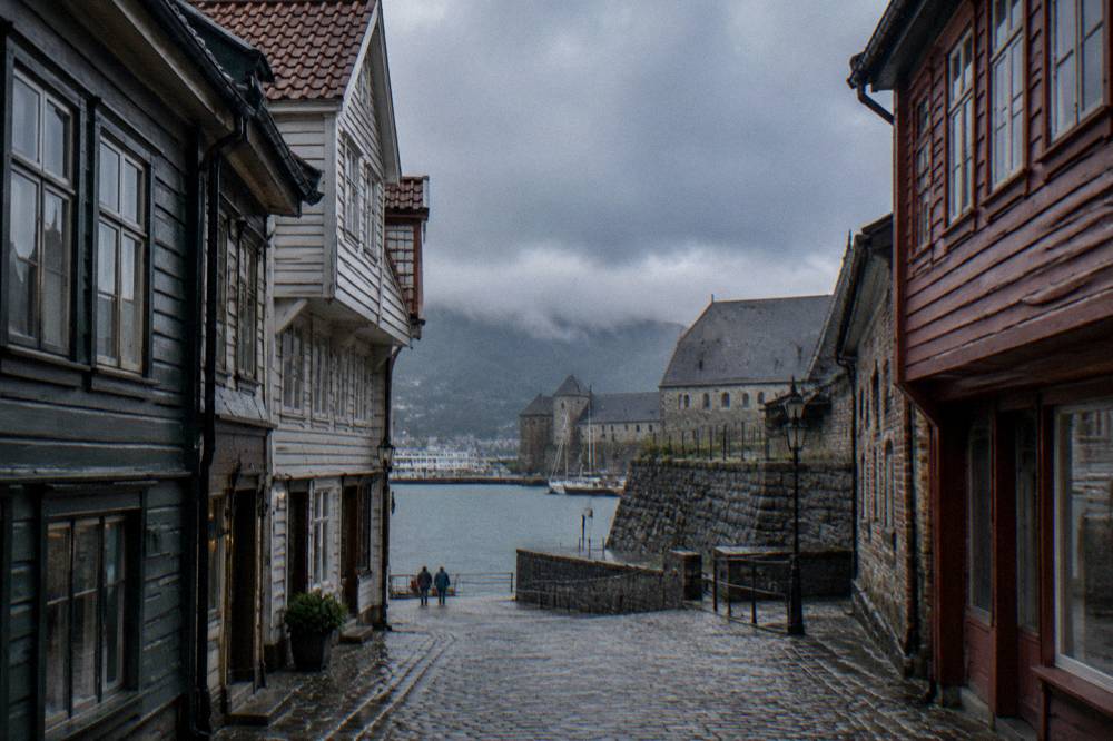 Stone fortress walls and a large medieval hall beside the harbour