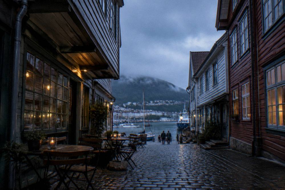 Small café tables set out on a cobbled lane between old wooden buildings