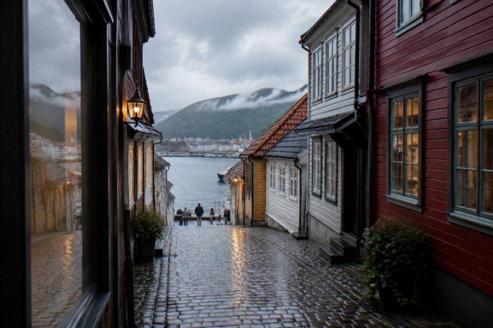 Wet cobbled street with old wooden buildings reflecting evening light after rain