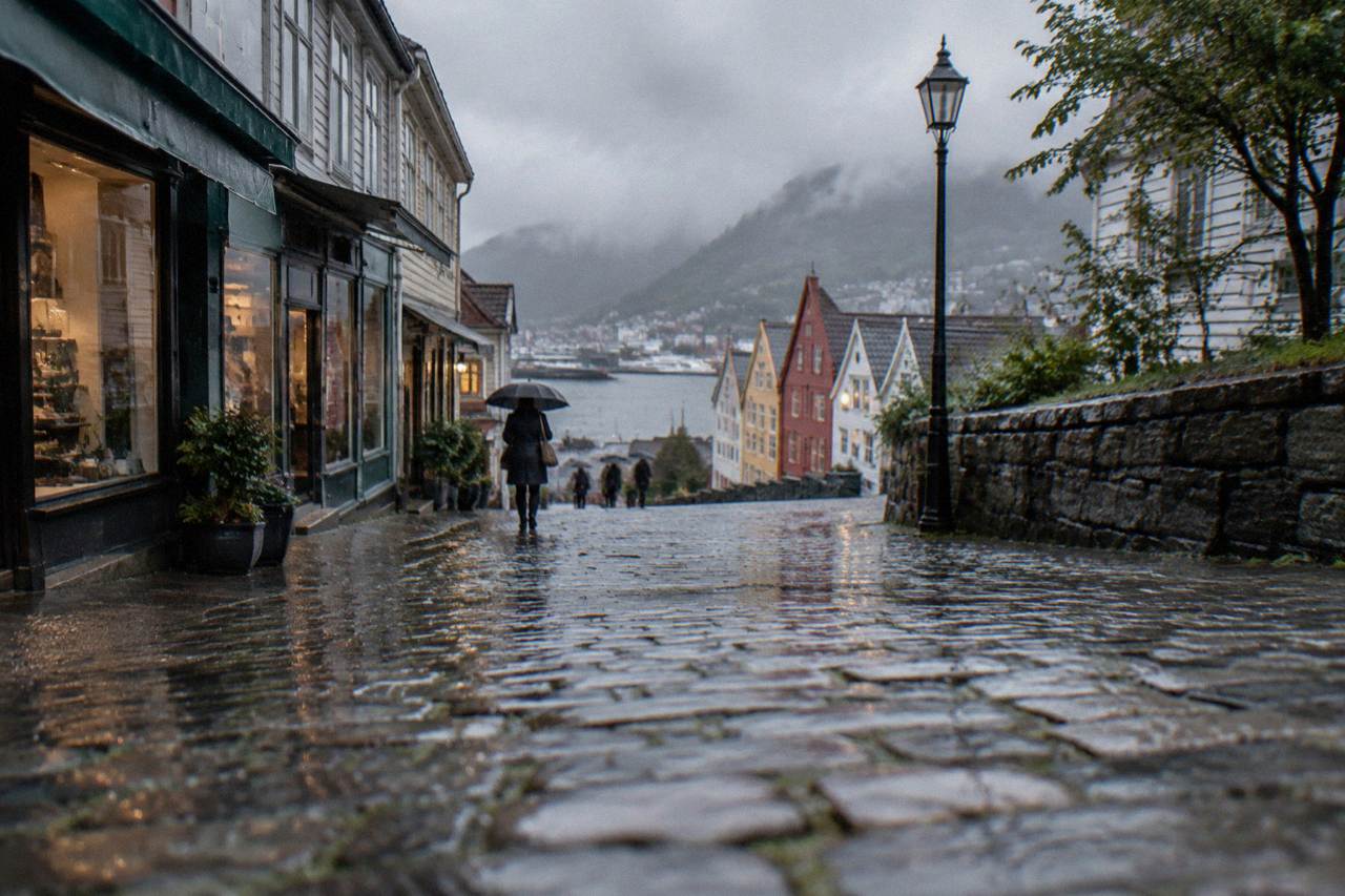 Cobbled pedestrian shopping street lined with small independent storefronts in Bergen, Norway