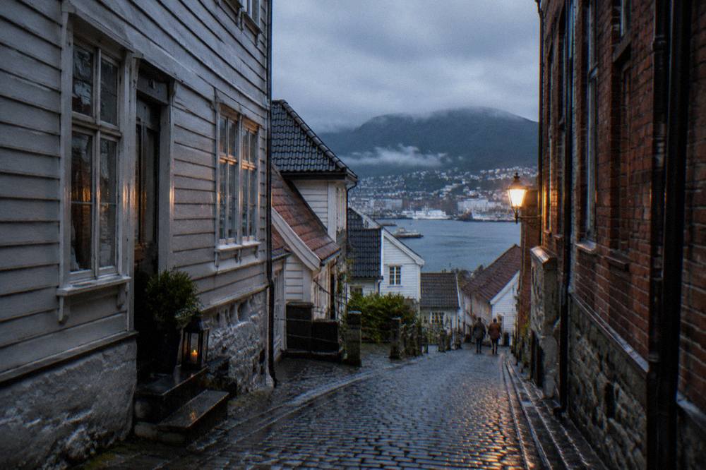 Narrow cobbled lane between old timber and brick buildings in central Bergen