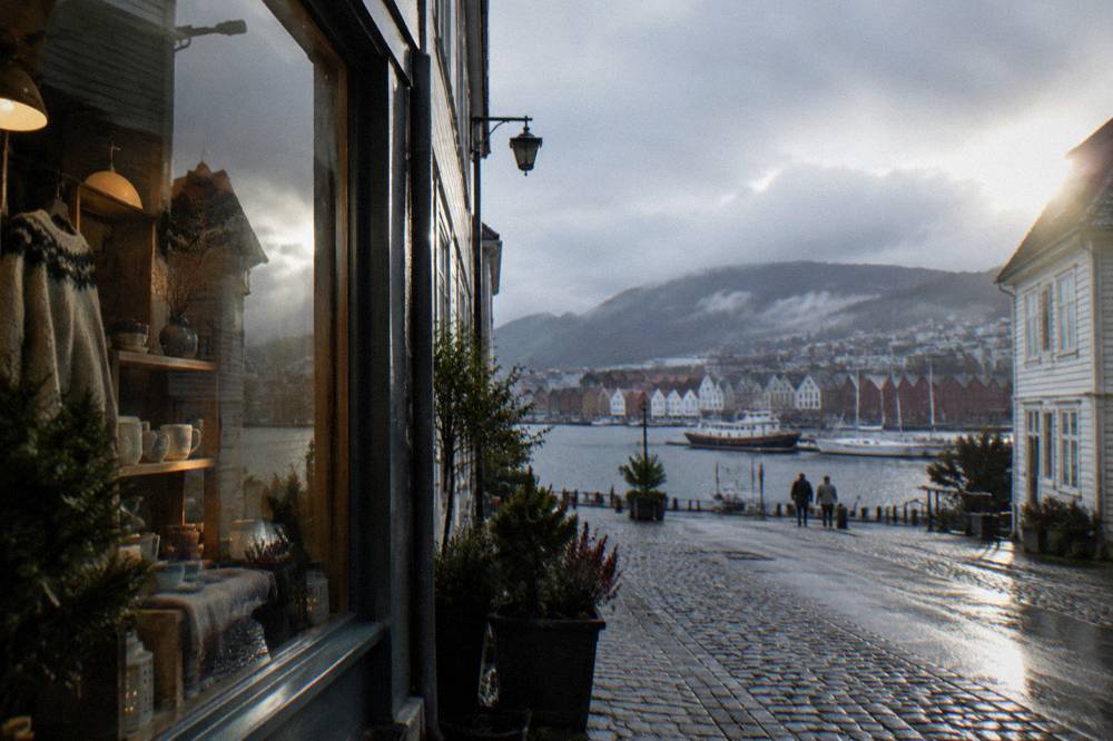 Small independent boutique window display on a cobbled street in Bergen