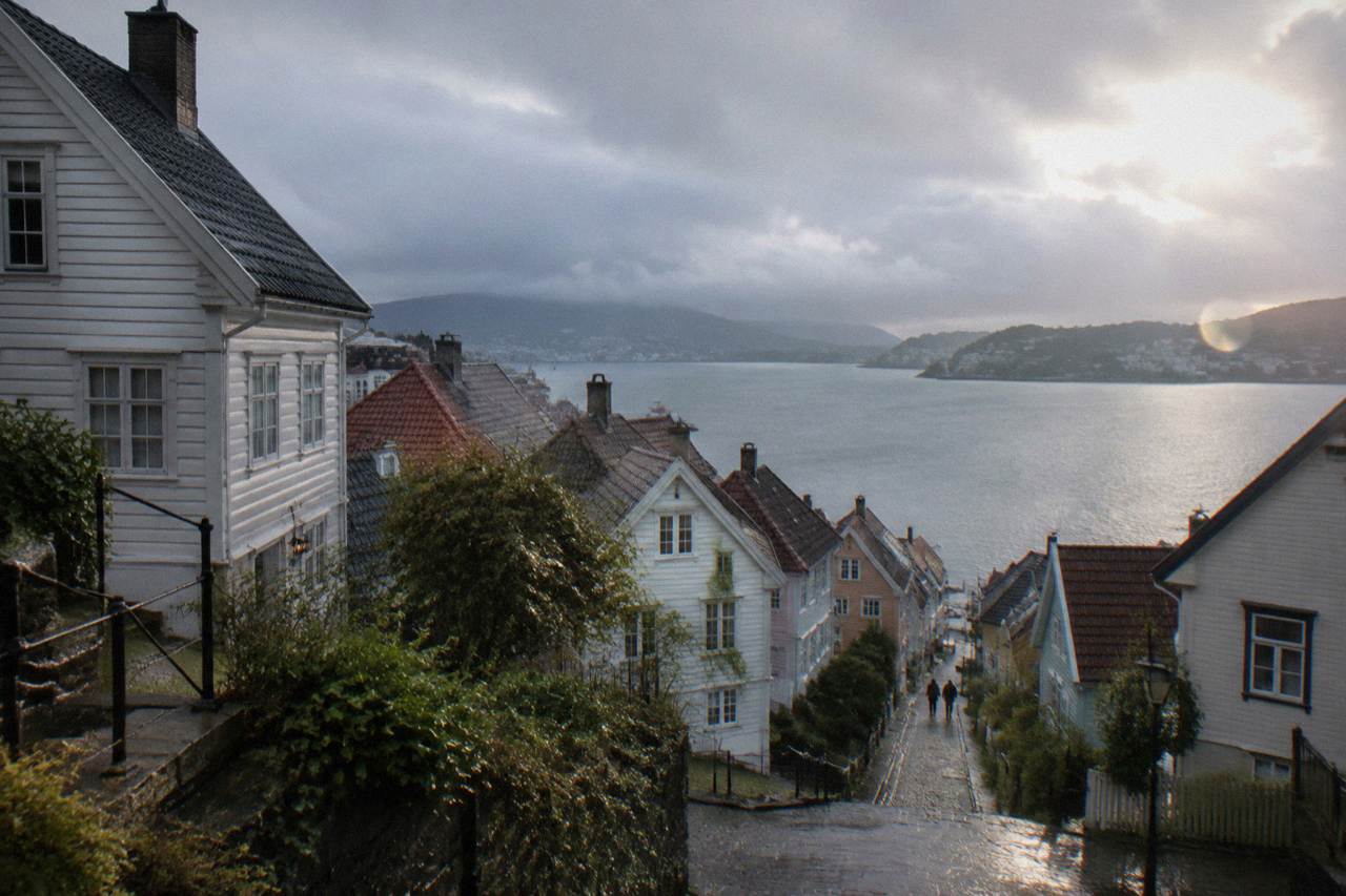 Old wooden houses on a hillside above the water on the Nordnes peninsula in Bergen