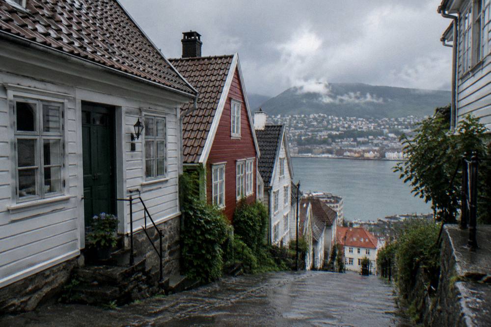 A narrow lane of small gabled wooden houses on a slope in Bergen