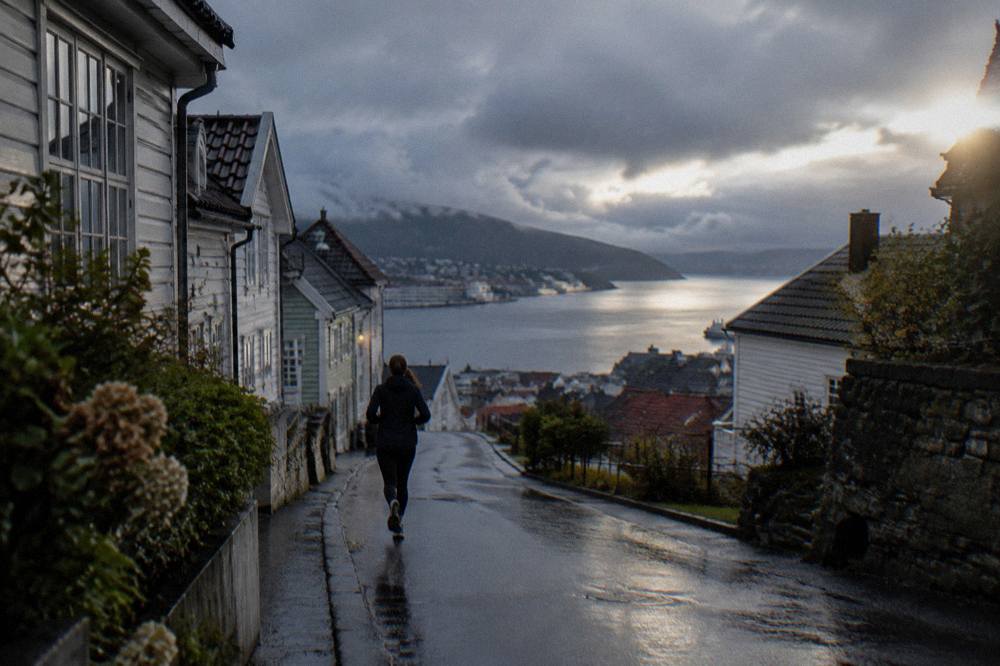 Dark clouds parting over the harbour water with city rooftops below