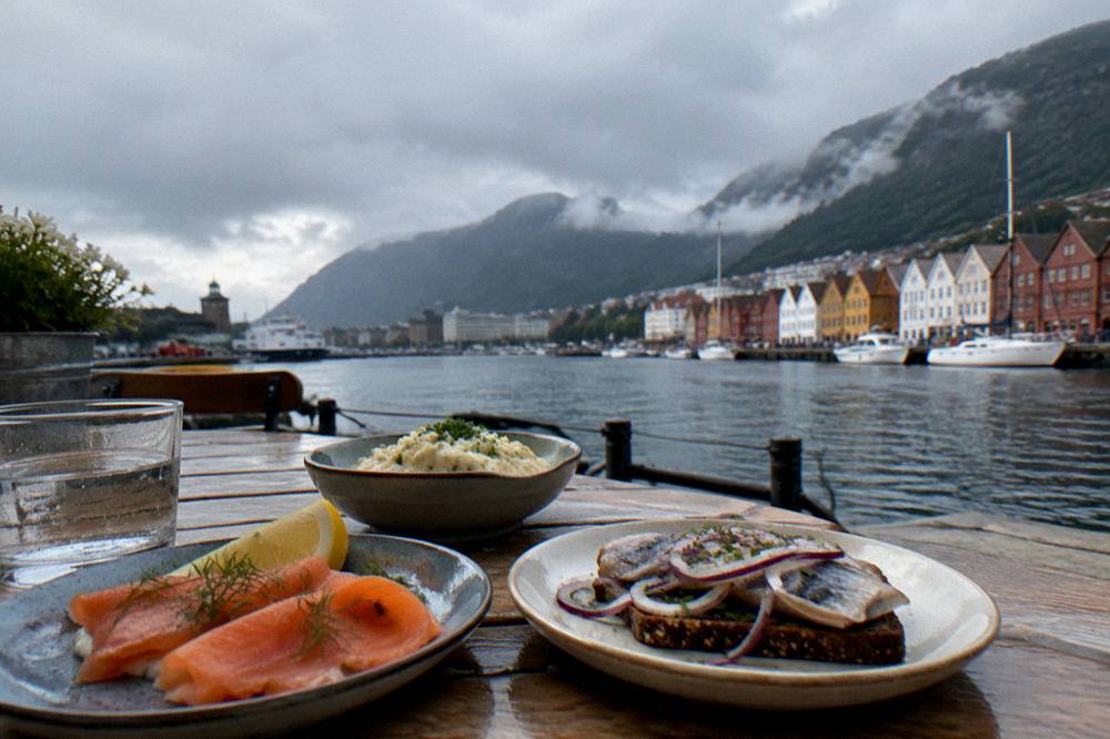 A wooden table with small plates of Norwegian food in a Bergen cafe