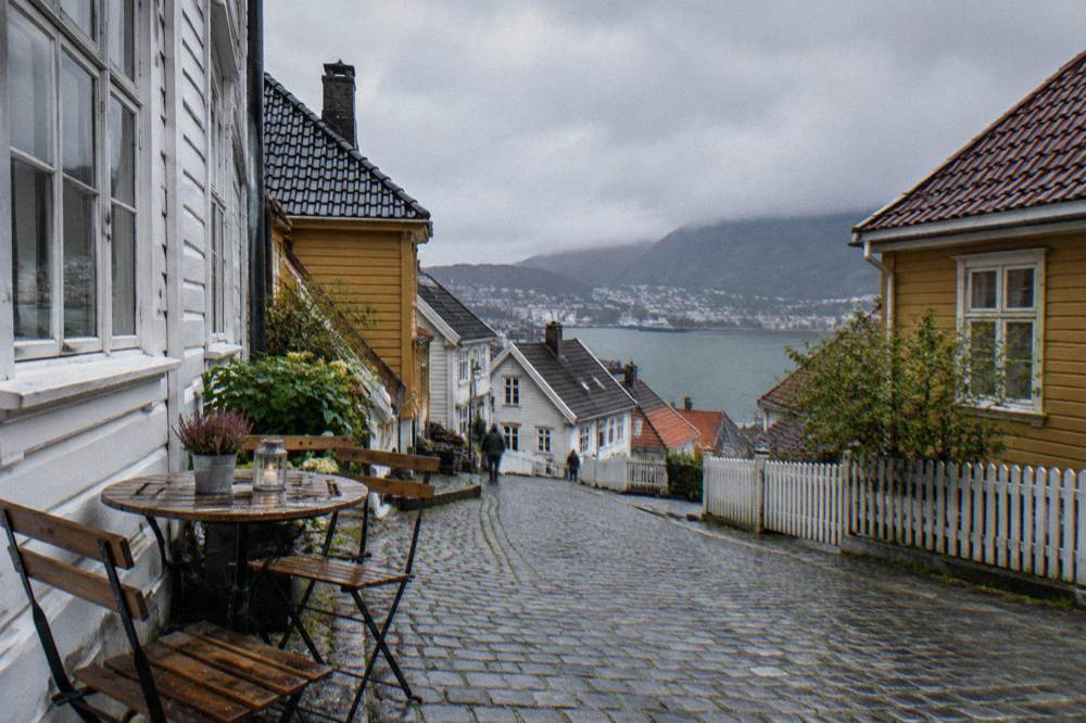A small café table set on a cobblestone street beside old timber buildings