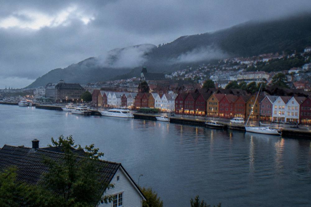 Colourful wooden Hanseatic buildings along the wharf in Bergen seen across the harbour water