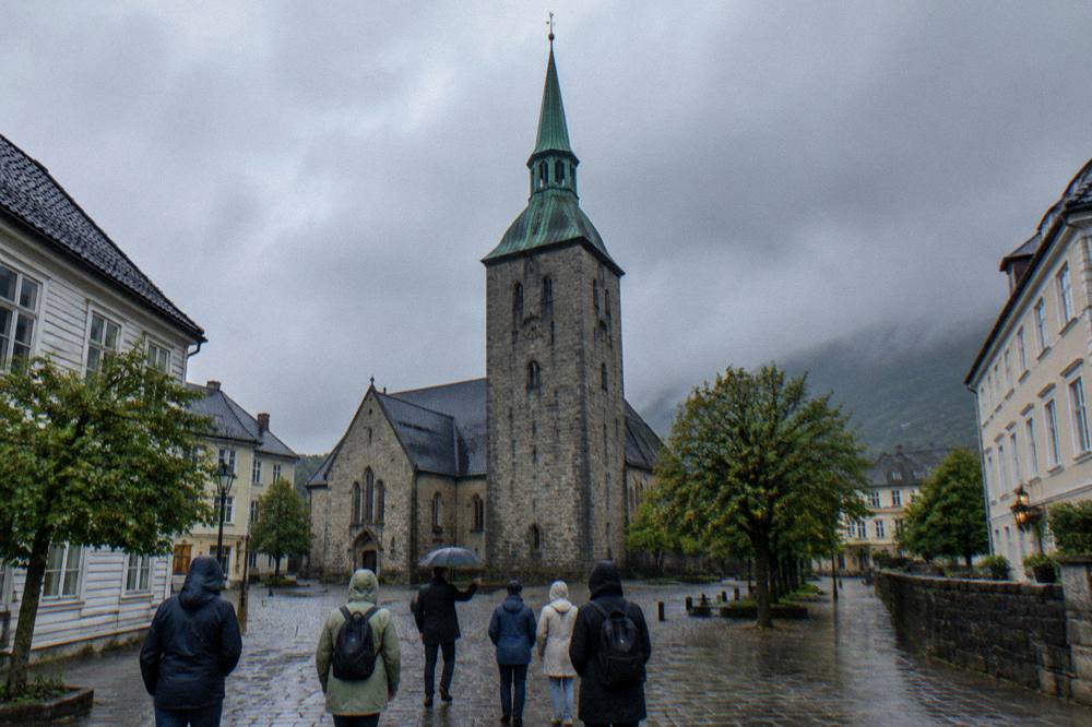 Visitors walking with a guide through a historic square in a Scandinavian city