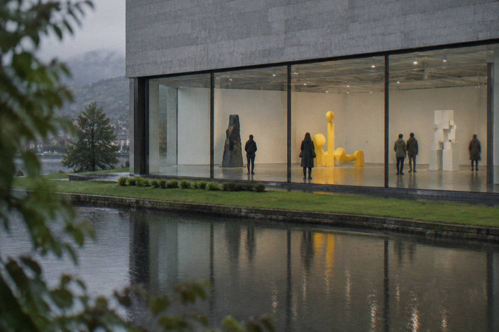 Visitors viewing a bright installation of contemporary sculpture in a high ceilinged gallery room