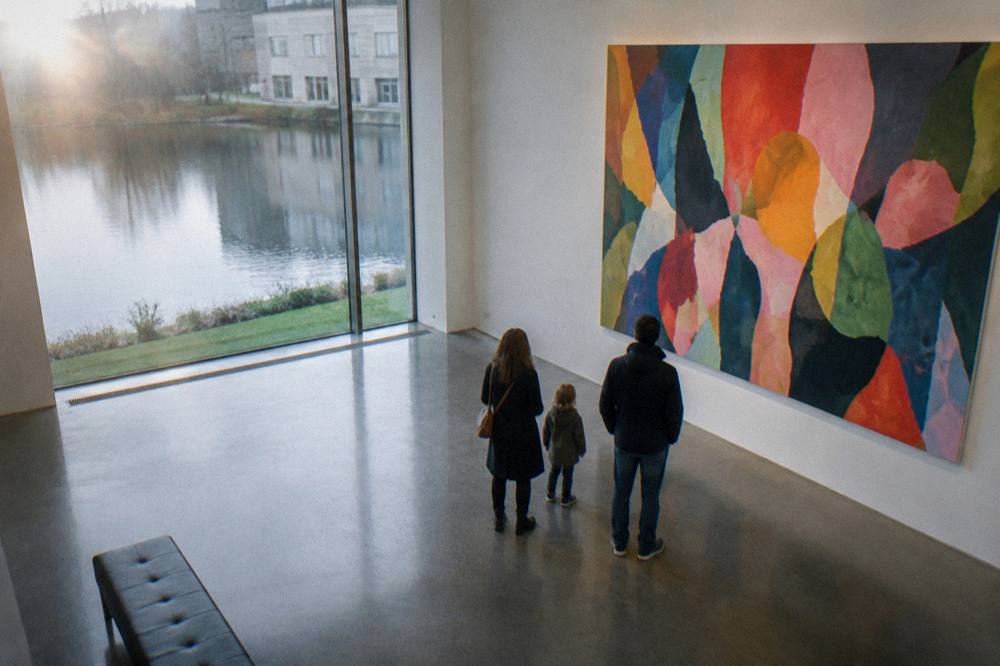 A family with a child looking at a colourful contemporary art wall in a bright museum room