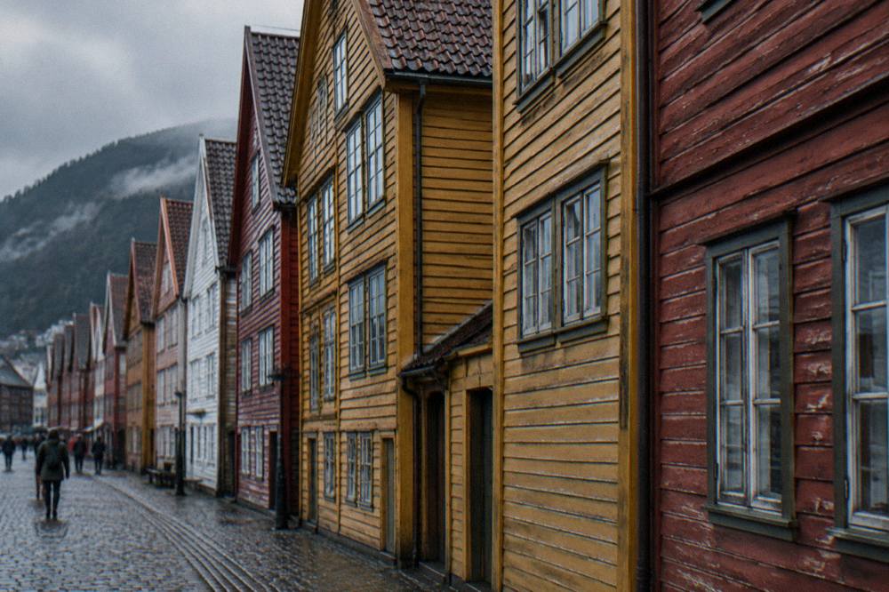 A close view of Bryggen's painted timber facades, showing weathered boards, small windows and stacked gable roofs.