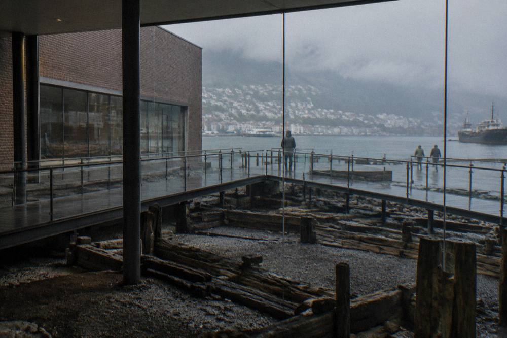 Excavated medieval building foundations displayed below walkways inside Bryggens Museum