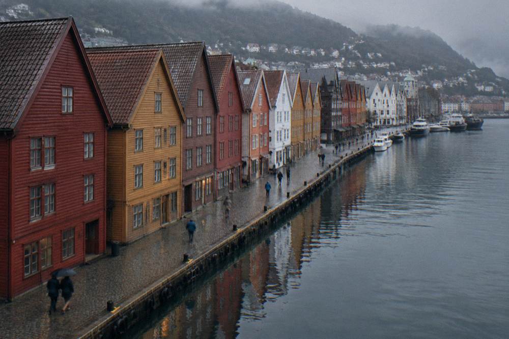 The colourful gabled Hanseatic warehouses of Bryggen reflected in the harbour water in Bergen