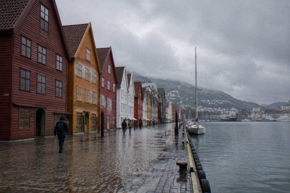 Rain-soaked cobblestones and wooden buildings along the wharf at Bryggen in Bergen