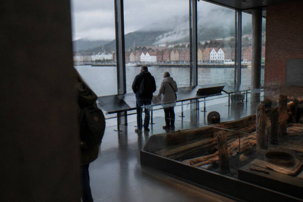 Visitors reading display panels about the Hanseatic period inside Bryggens Museum