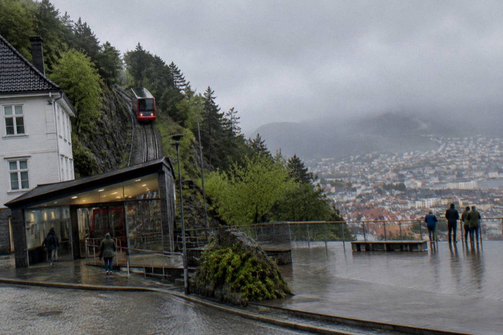 The Fløibanen lower station entrance on a street corner in central Bergen with the funicular track rising behind it