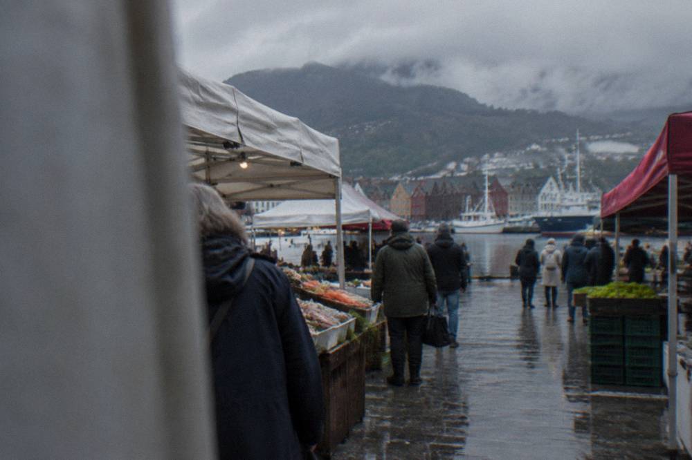 People browsing food stalls at an outdoor market near the harbour in Bergen