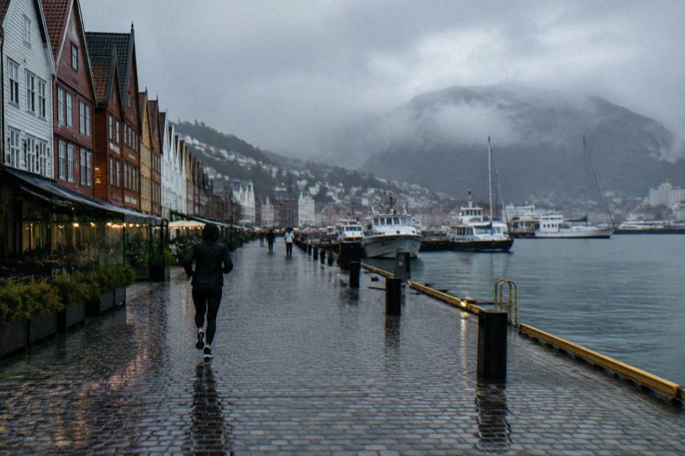 Rain falling on a harbour street with reflections on wet cobblestones in Bergen