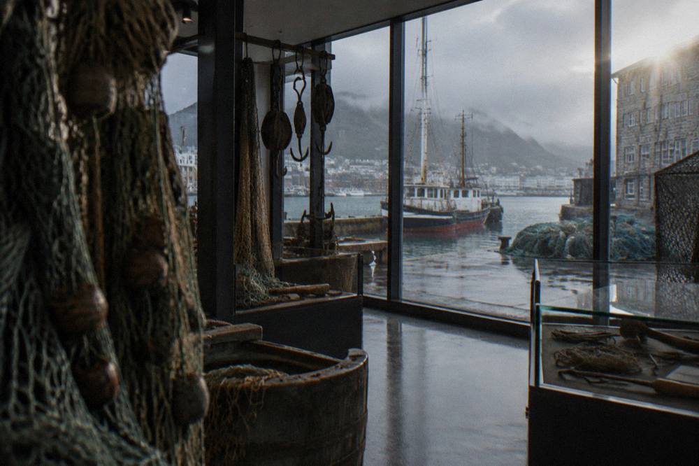 Displays of old fishing nets, hooks and maritime tools inside a museum interior