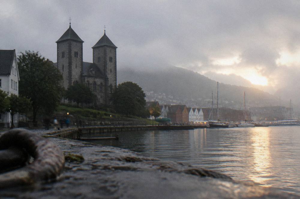 Sunset light on the harbor with church towers and warehouse gables in silhouette