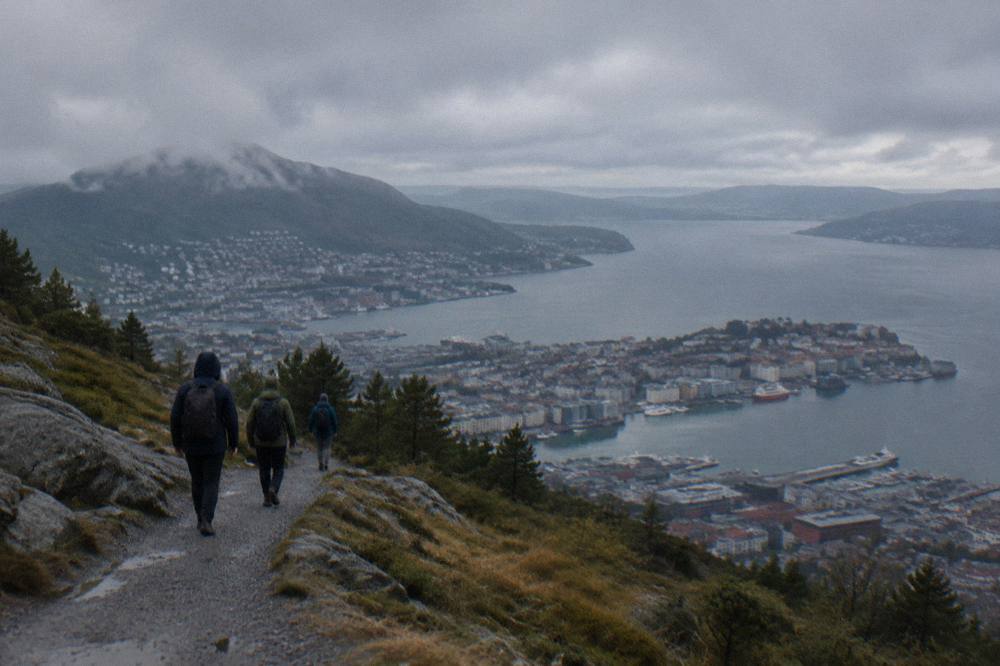 Walkers on a gravel upland path above Bergen with the harbour and fjord beyond