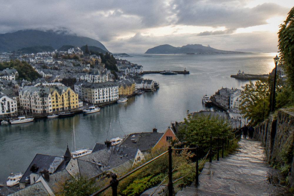 A stone staircase path climbing a hillside with a panoramic view over islands and open sea