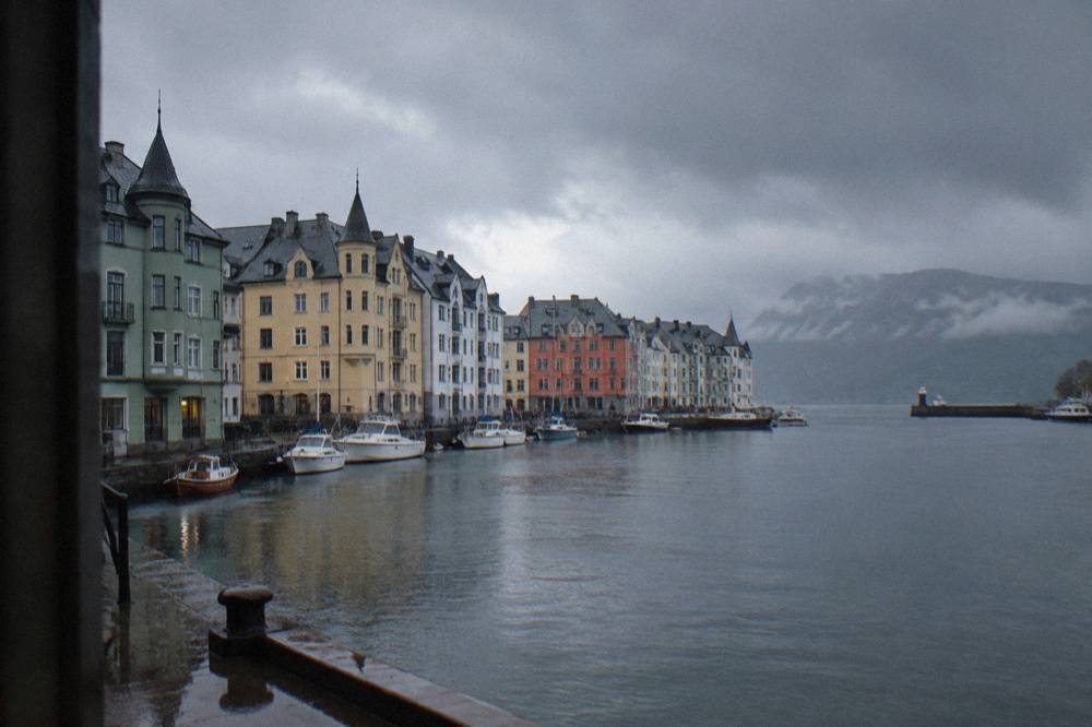 Rain clouds moving over a Norwegian fjord with moody light on dark water
