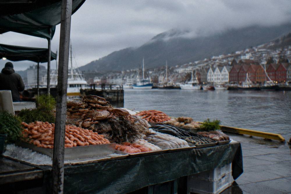 A table of Norwegian seafood dishes at an outdoor market stall in Bergen