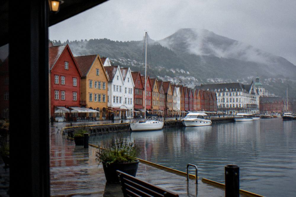 Colourful wooden hanseatic buildings standing along a harbour wharf on a rainy afternoon