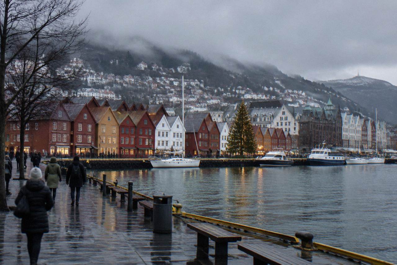 Decorated timber buildings and a lit Christmas tree beside the harbour in Bergen in December