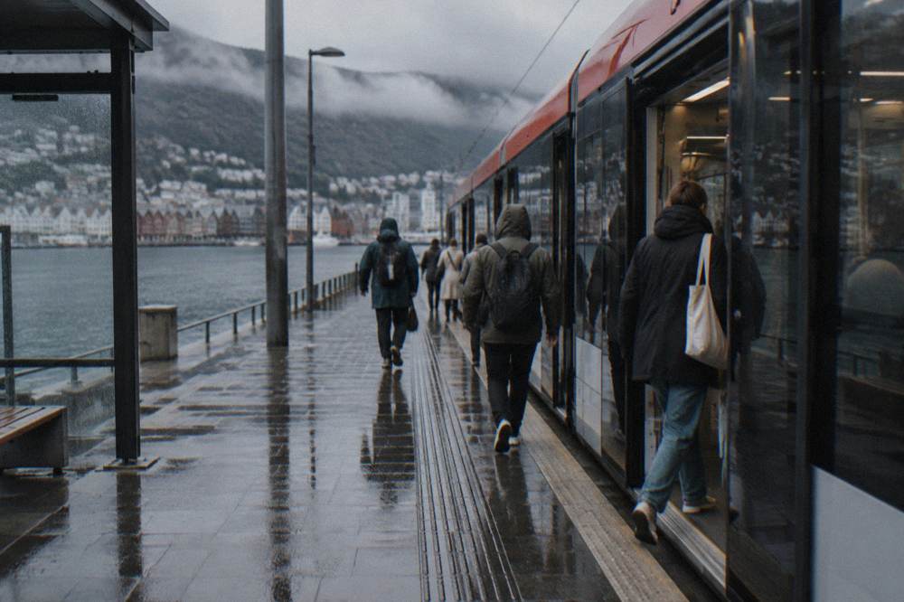 Passengers boarding a light rail tram at a platform in central Bergen