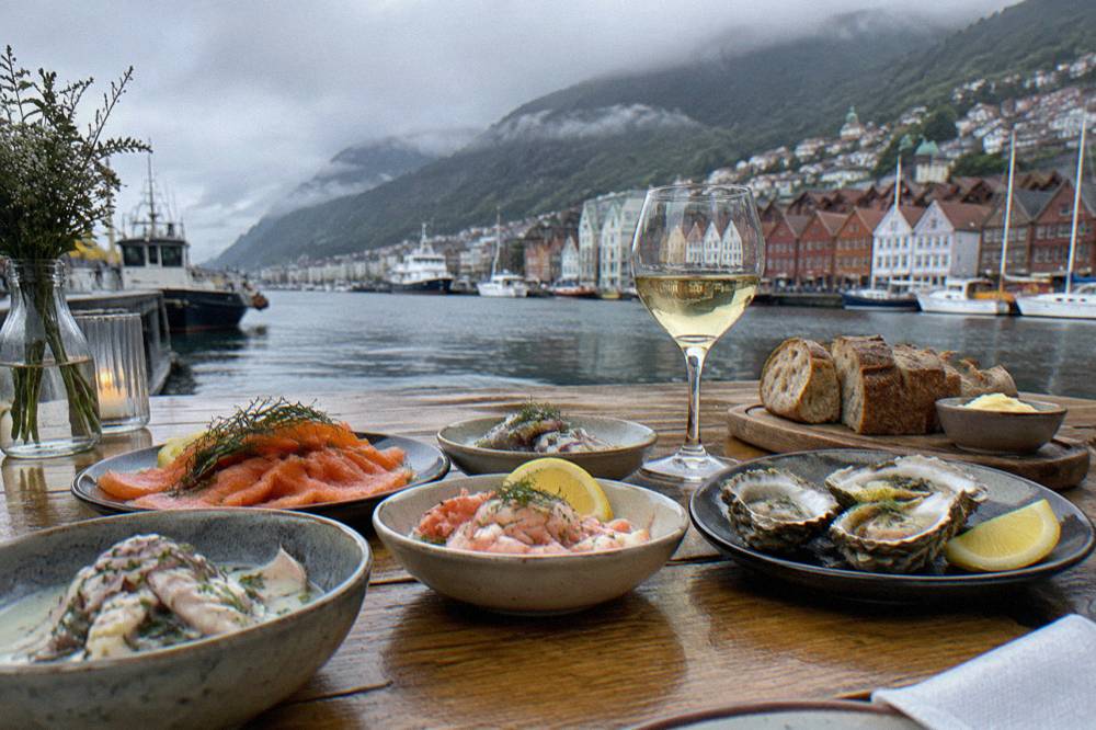 A table of small seafood dishes and fresh bread prepared for a tasting group in a Bergen restaurant