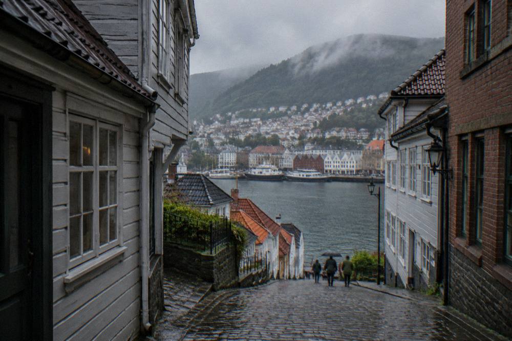 View over Bergen old town and harbour with green mountains rising behind the rooftops