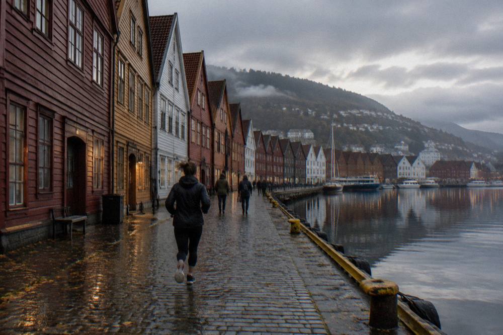Bryggen wharf buildings reflected in a calm harbor at dusk in autumn