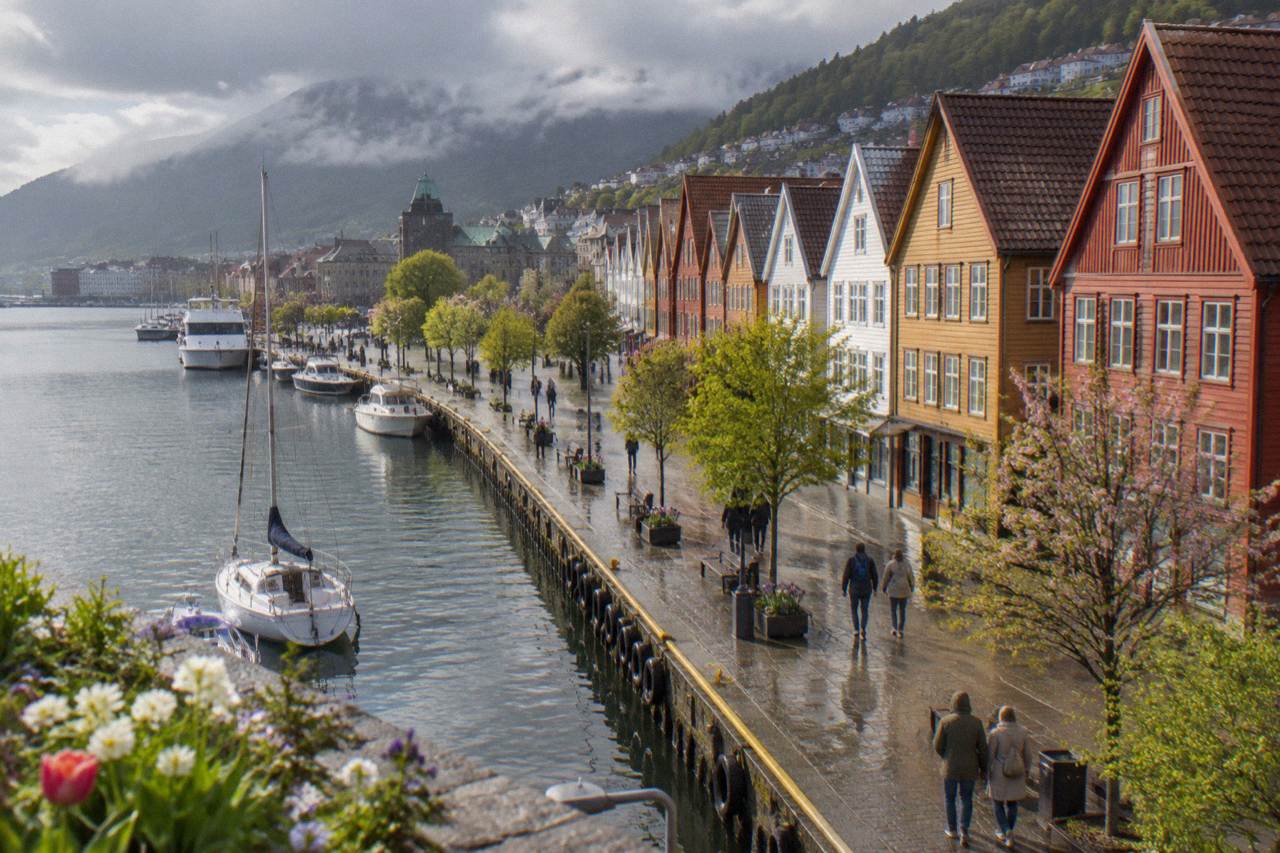 Colorful wooden houses along the wharf in Bergen on a bright spring day with flowers in bloom