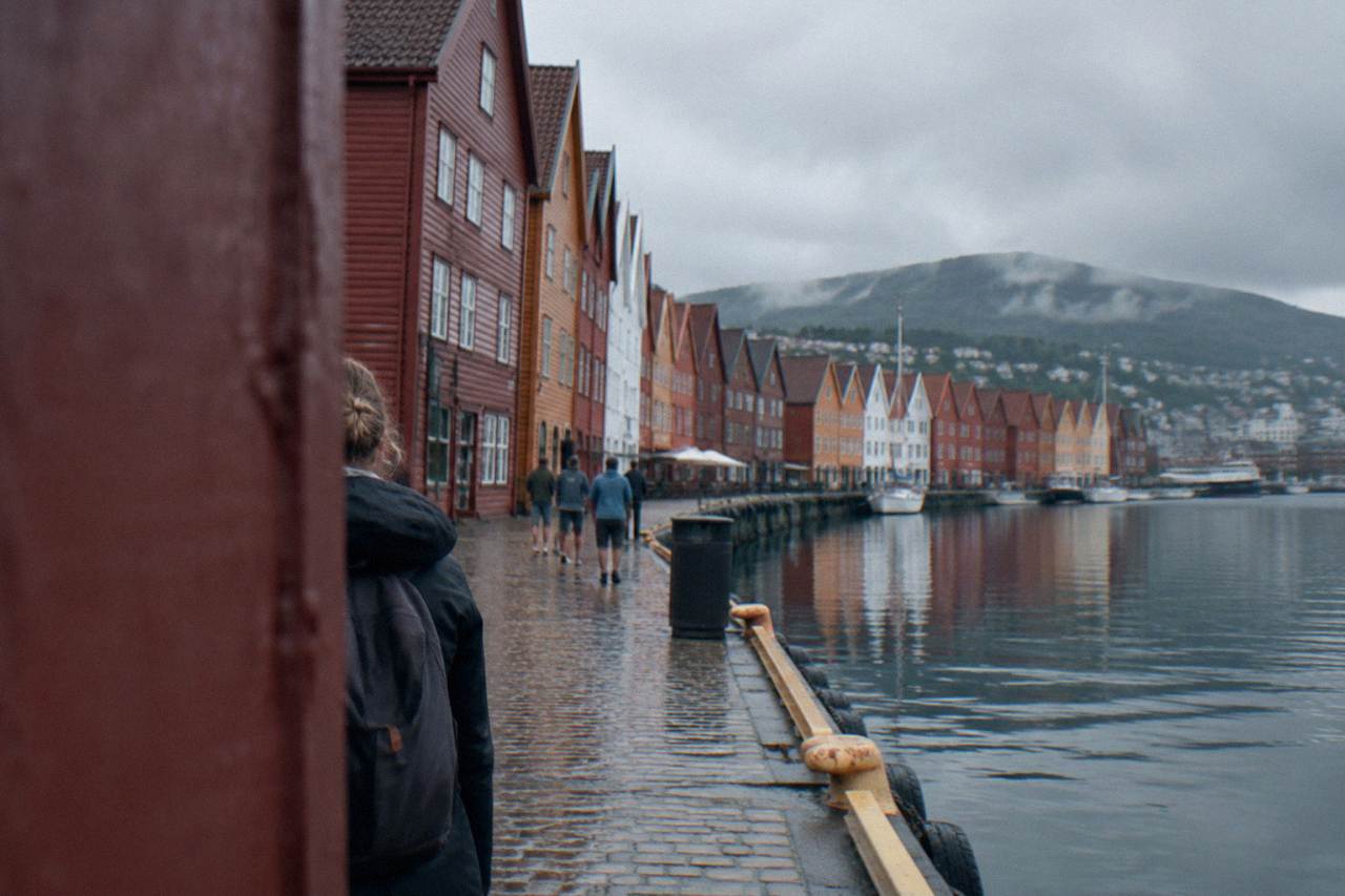 Colourful wooden houses of Bryggen wharf in Bergen reflected in the harbour water on a bright summer day