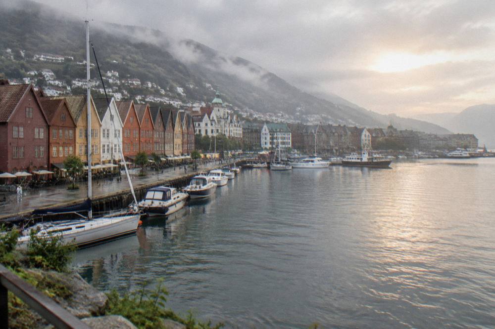 Harbour front in Bergen at sunset with boats moored along the quay and warm light on the buildings