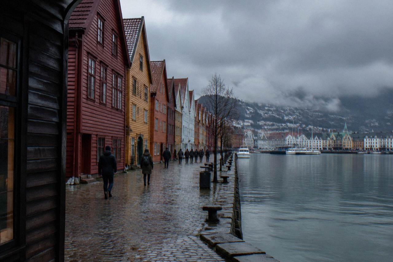 Bergen's colourful wooden houses at Bryggen under a dark winter sky with the harbour in front