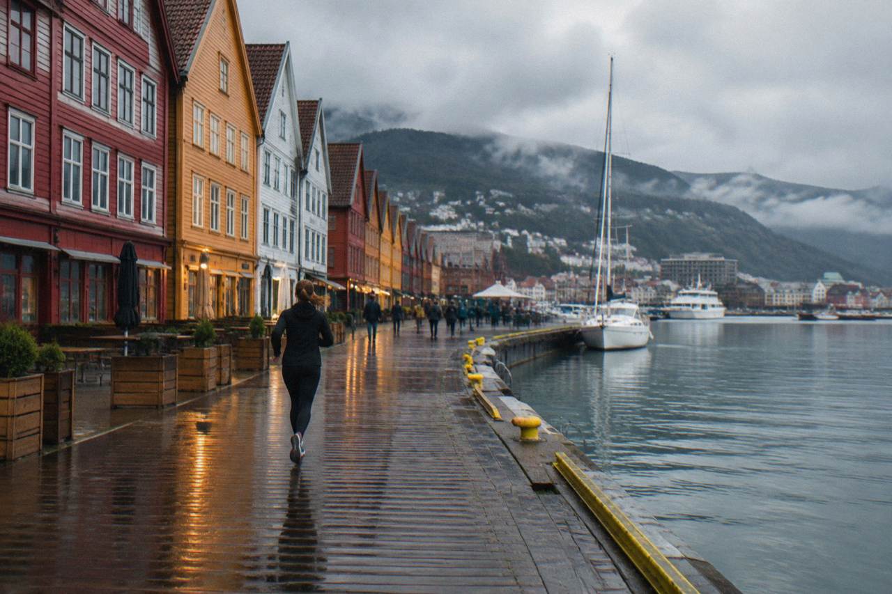 Colourful wooden buildings along the Bergen wharf glowing under evening lights