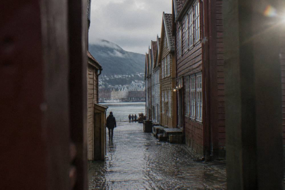 A narrow alley between weathered wooden buildings in the Bryggen hanseatic quarter