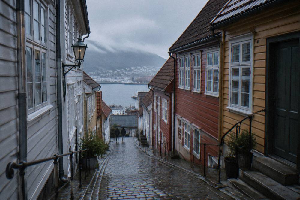 Narrow cobblestone alley in the old Hanseatic quarter of Bergen with wooden buildings on both sides