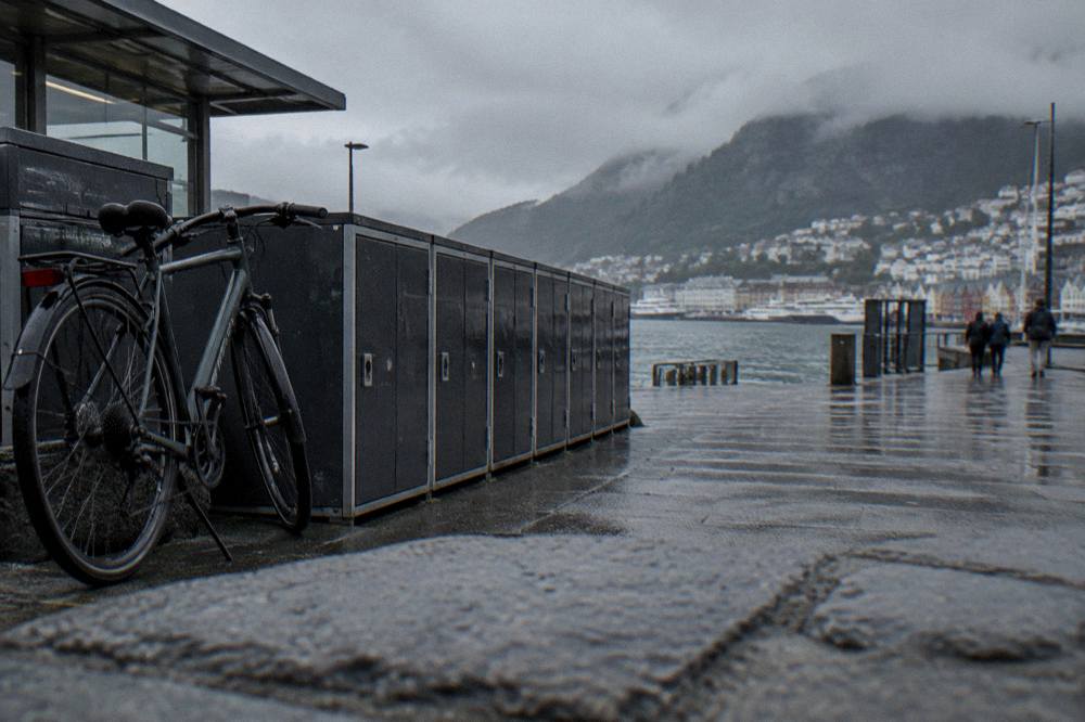 Luggage lockers and a parked bicycle outside a train station in a Norwegian city